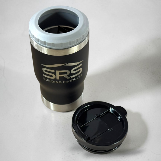 A black insulated travel tumbler with a light gray silicone rim and stainless steel accents, shown with its black lid placed beside it on a light gray surface. The tumbler is branded with the SRS Building Products logo.