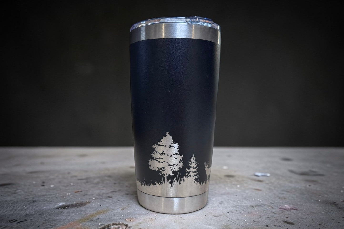 Black tumbler with tree design on a dark surface