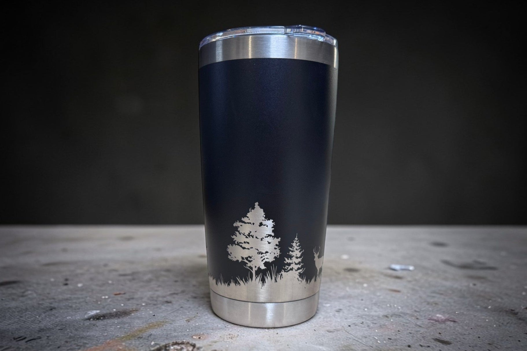 Black tumbler with tree design on a dark surface