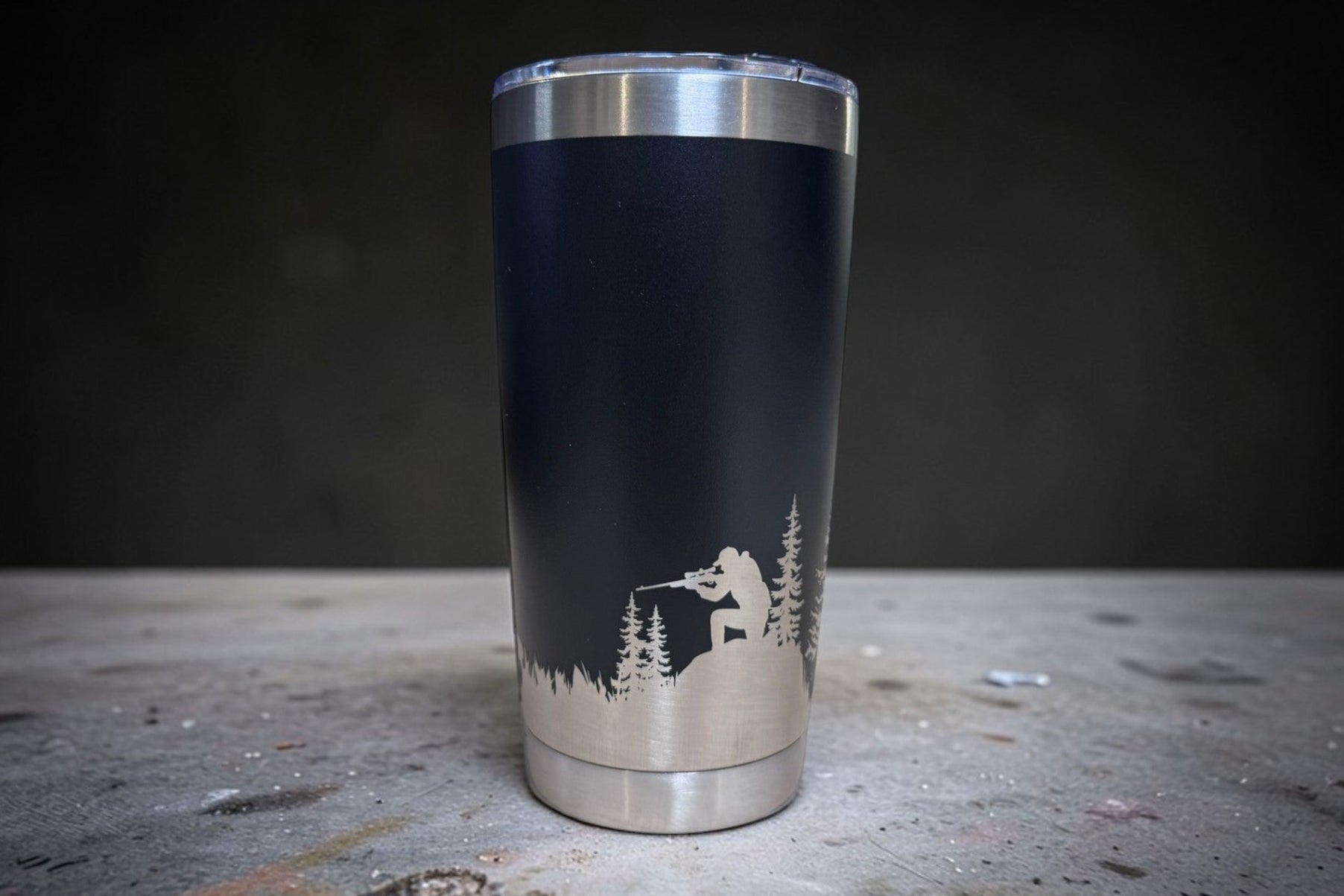 Tumbler with hunter and forest design on a dark background